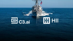 Image of a U.S. navy ship sailing towards the camera with the water split between the logos for C3.ai and HII, illustrating their increasing partnership.